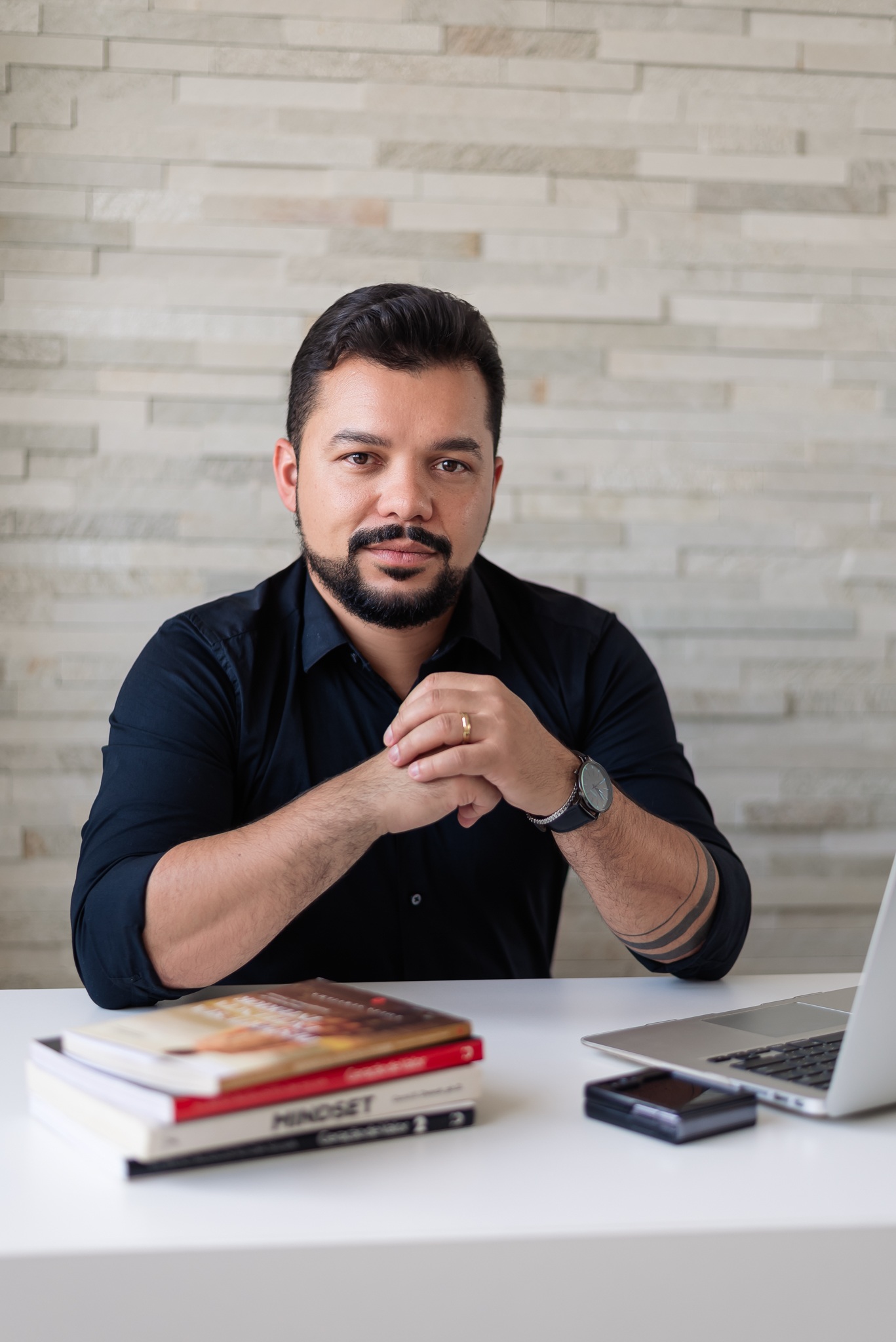 Louis Servilha sentado à mesa, com livros e computador
